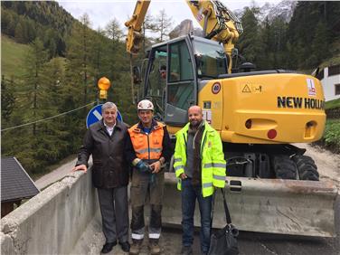 Ortsaugenschein auf der Staatsstraße bei den Sicherungsarbeiten in Plan de Gralba: LR Florian Mussner, ein Bauarbeiter und der Geometer Roberto Giordani vom Amt für Straßenbau Mitte-Süd (FOTO: LPA/Abteilung Straßendienst)